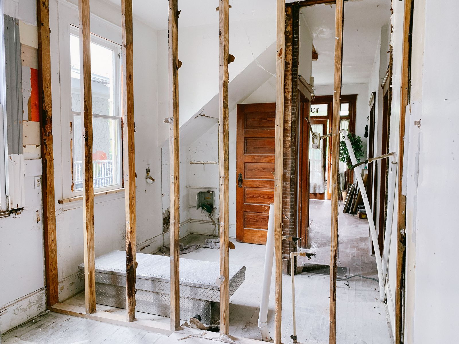 Interior of a home under construction with exposed timber framing and new openings