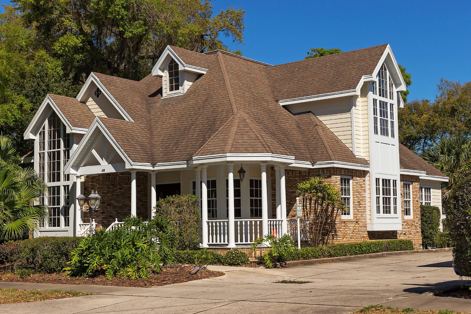 Large brick and stone home with a multi-gabled asphalt shingle roof
